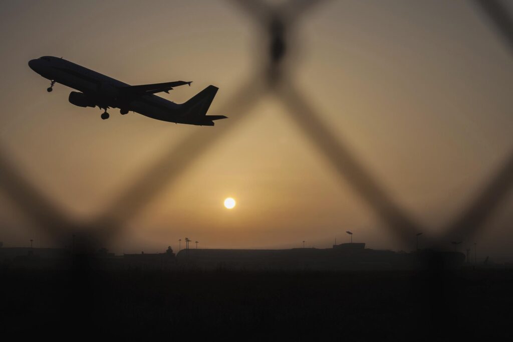Airplane taking off at sunset
